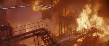 Movie still from “Backdraft” (1991), directed by Ron Howard – A fire is burning in a building that has stairs leading up to it; Extreme Wide shot, High angle