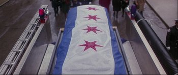 Movie still from “Backdraft” (1991), directed by Ron Howard – A flag that has been folded in the shape of a star; Wide shot, High angle