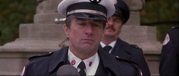 Movie still from “Backdraft” (1991), directed by Ron Howard – A man in a fireman's uniform is being interviewed by a microphone; Close Up shot, Low angle