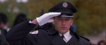 Movie still from “Backdraft” (1991), directed by Ron Howard – A man in uniform saluting while wearing a white glove; Close Up shot, Low angle