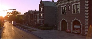 Movie still from “Backdraft” (1991), directed by Ron Howard – A row of houses on a street at dusk or dawn; Extreme Wide shot, High angle