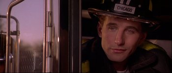 Movie still from “Backdraft” (1991), directed by Ron Howard – A man wearing a fireman's hat looking out a window; Close Up shot, Low angle