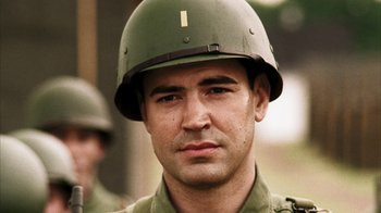 Movie still from “Band of Brothers” (2001), directed by David Frankel – A man wearing a green helmet is looking at the camera; Close Up shot, Over the shoulder angle