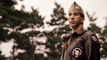 Movie still from “Band of Brothers” (2001), directed by David Frankel – A man in a military uniform standing in front of trees; Close Up shot, Low angle