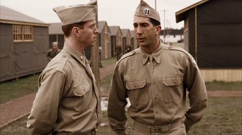 Movie still from “Band of Brothers” (2001), directed by David Frankel – A couple of men standing next to each other; Medium shot, Over the shoulder angle