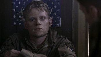 Movie still from “Band of Brothers” (2001), directed by David Frankel – A man in a military uniform sitting on a train; Close Up shot, Over the shoulder angle