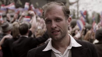 Movie still from “Band of Brothers” (2001), directed by David Frankel – A person wearing a suit and tie; Close Up shot, Over the shoulder angle