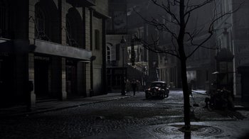 Movie still from “Band of Brothers” (2001), directed by David Frankel – A car parked on the side of the street at night; Extreme Wide shot, High angle
