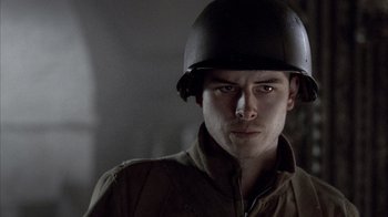 Movie still from “Band of Brothers” (2001), directed by David Frankel – A man wearing a military uniform and a helmet; Close Up shot, Low angle