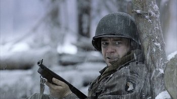 Movie still from “Band of Brothers” (2001), directed by David Frankel – A man holding a rifle in the snow; Close Up shot, Over the shoulder angle