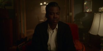 Movie still from “Fargo” (2014), created by Noah Hawley – A man in a suit sitting in a chair; Close Up shot, Over the shoulder angle