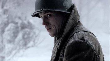 Movie still from “Band of Brothers” (2001), directed by David Frankel – A man wearing a helmet and a coat; Close Up shot, Low angle