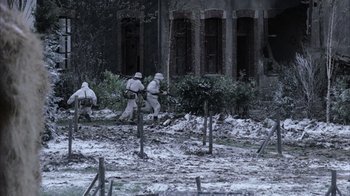 Movie still from “Band of Brothers” (2001), directed by David Frankel – A group of men in white suits walking across a field; Wide shot, High angle
