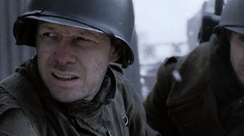 Movie still from “Band of Brothers” (2001), directed by David Frankel – A man wearing a helmet and a jacket; Close Up shot, Over the shoulder angle
