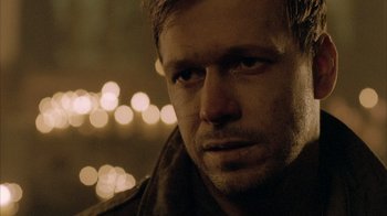 Movie still from “Band of Brothers” (2001), directed by David Frankel – A man's face in front of lights; Close Up shot, Over the shoulder angle