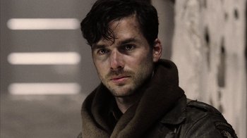 Movie still from “Band of Brothers” (2001), directed by David Frankel – A person wearing a coat and a scarf; Close Up shot, Over the shoulder angle