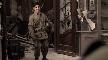 Movie still from “Band of Brothers” (2001), directed by David Frankel – A young man in uniform standing in front of a door; Medium shot, Over the shoulder angle
