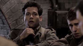 Movie still from “Band of Brothers” (2001), directed by David Frankel – A man in a trench coat is looking at the camera; Close Up shot, High angle