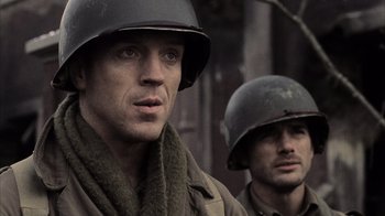 Movie still from “Band of Brothers” (2001), directed by David Frankel – Two men in military uniforms are standing next to each other; Close Up shot, Over the shoulder angle
