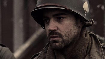 Movie still from “Band of Brothers” (2001), directed by David Frankel – A man wearing a military helmet and a scarf; Close Up shot, Low angle