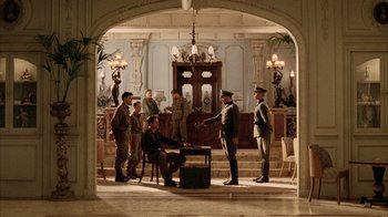 Movie still from “Band of Brothers” (2001), directed by David Frankel – A group of men standing around a table in a room; Wide shot, High angle