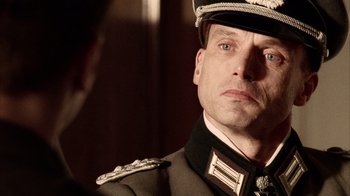 Movie still from “Band of Brothers” (2001), directed by David Frankel – A person wearing a military uniform; Close Up shot, Over the shoulder angle