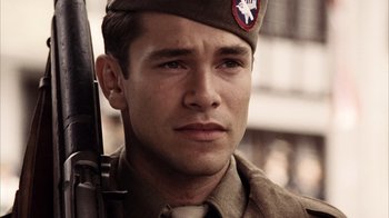 Movie still from “Band of Brothers” (2001), directed by David Frankel – A man in a military uniform holding a rifle; Close Up shot, High angle