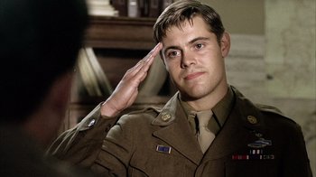 Movie still from “Band of Brothers” (2001), directed by David Frankel – A man in uniform saluting while wearing a hat; Close Up shot, Low angle