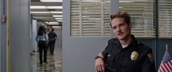 Movie still from “Band of Robbers” (2015), directed by Adam Nee – A man in a police uniform leaning against a wall; Close Up shot, Over the shoulder angle