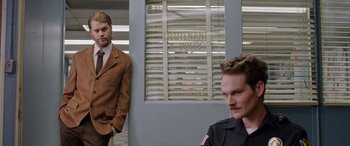 Movie still from “Band of Robbers” (2015), directed by Adam Nee – Two men standing in front of a building; Medium shot, Over the shoulder angle