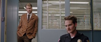 Movie still from “Band of Robbers” (2015), directed by Adam Nee – Two men standing in front of a police station; Medium shot, Over the shoulder angle