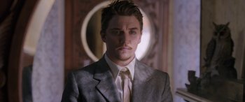 Movie still from “Band of Robbers” (2015), directed by Adam Nee – A man wearing a suit and tie in front of a mirror; Close Up shot, Low angle