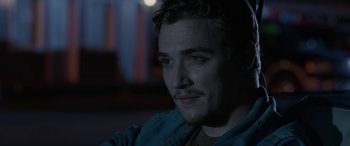 Movie still from “Band of Robbers” (2015), directed by Adam Nee – A person sitting in a room; Close Up shot, Over the shoulder angle