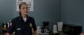 Movie still from “Band of Robbers” (2015), directed by Adam Nee – A police officer standing in front of a coffee maker; Close Up shot, Over the shoulder angle
