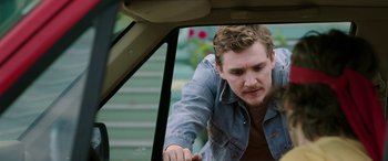 Movie still from “Band of Robbers” (2015), directed by Adam Nee – A man leaning on the side of a car window; Close Up shot, Over the shoulder angle