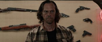 Movie still from “Band of Robbers” (2015), directed by Adam Nee – A person wearing a plaid shirt; Close Up shot, Over the shoulder angle