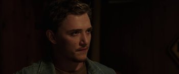Movie still from “Band of Robbers” (2015), directed by Adam Nee – A person wearing a jean jacket; Close Up shot, Over the shoulder angle