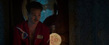 Movie still from “Band of Robbers” (2015), directed by Adam Nee – A man sitting in front of a table with a lamp in front of him; Close Up shot, Over the shoulder angle