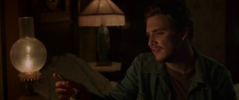 Movie still from “Band of Robbers” (2015), directed by Adam Nee – A man sitting at a table looking at papers; Close Up shot, Over the shoulder angle