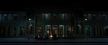 Movie still from “Band of Robbers” (2015), directed by Adam Nee – A car parked in front of a building at night; Extreme Wide shot, Low angle