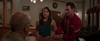 Movie still from “Band of Robbers” (2015), directed by Adam Nee – A woman sitting at a table next to a man; Medium shot, Over the shoulder angle