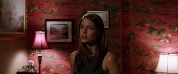 Movie still from “Band of Robbers” (2015), directed by Adam Nee – A woman standing in front of a red wall; Medium shot, Over the shoulder angle