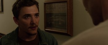 Movie still from “Band of Robbers” (2015), directed by Adam Nee – A person in front of a picture; Close Up shot, Over the shoulder angle