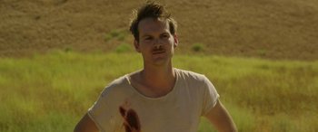 Movie still from “Band of Robbers” (2015), directed by Adam Nee – A man with a beard and a mustache with a blood stain on his face; Close Up shot, Over the shoulder angle