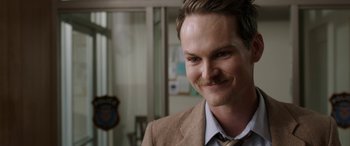 Movie still from “Band of Robbers” (2015), directed by Adam Nee – A person wearing a suit and tie; Close Up shot, Over the shoulder angle