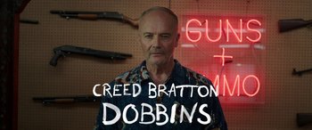 Movie still from “Band of Robbers” (2015), directed by Adam Nee – A bald man with a beard and mustache wearing a hawaiian shirt; Medium shot, Low angle