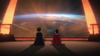 Movie still from “Batman and Superman: Battle of the Super Sons” (2022), directed by Matt Peters – Two people are sitting in front of a large screen; Extreme Wide shot, Low angle