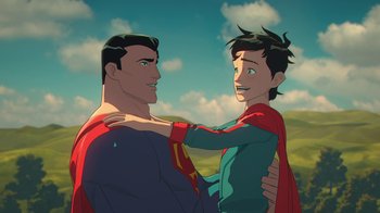 Movie still from “Batman and Superman: Battle of the Super Sons” (2022), directed by Matt Peters – A man and a boy are hugging each other in a field; Close Up shot, Over the shoulder angle