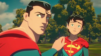 Movie still from “Batman and Superman: Battle of the Super Sons” (2022), directed by Matt Peters – A man and a boy are standing next to each other; Close Up shot, Over the shoulder angle