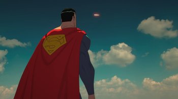 Movie still from “Batman and Superman: Battle of the Super Sons” (2022), directed by Matt Peters – A man in a superman costume looking up at a flying saucer; Extreme Wide shot, Low angle